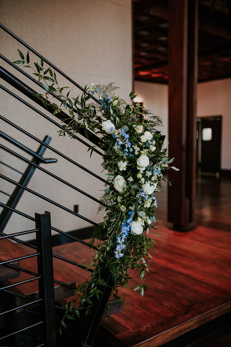 Staircase decorated with greenery and white flowers