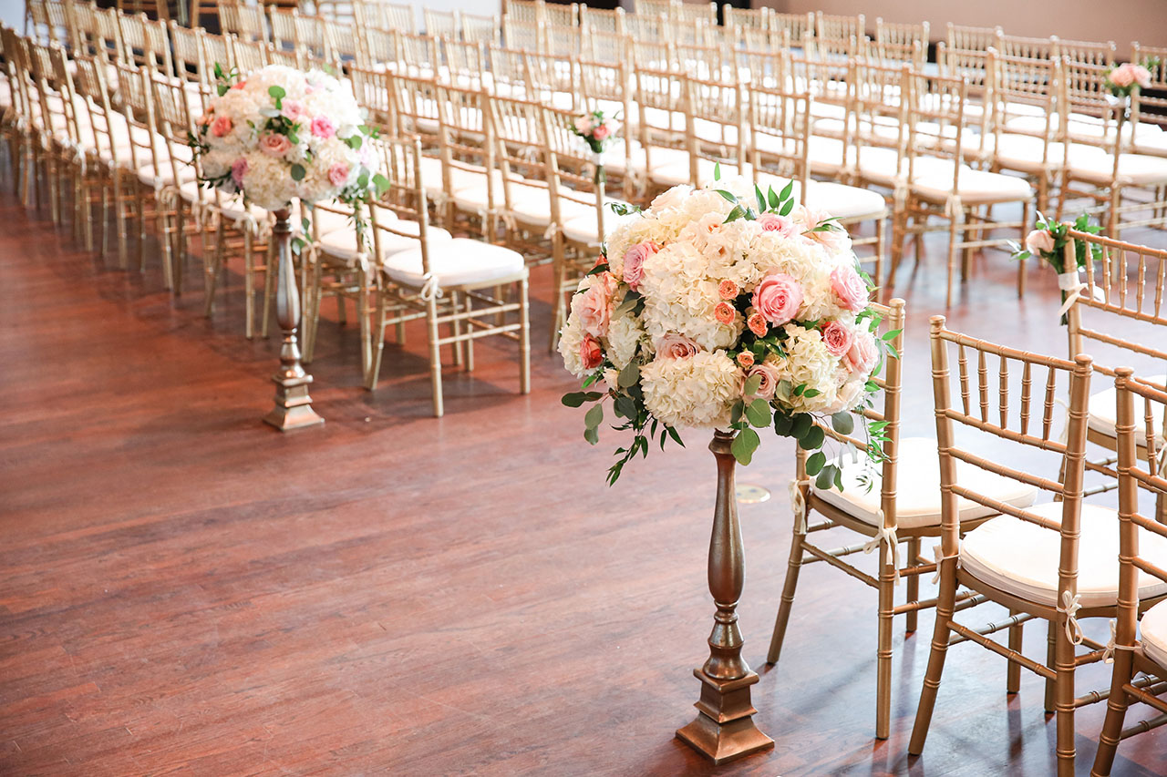 Aisle arrangements with white hydrangeas, pink roses, and eucalyptus leaves