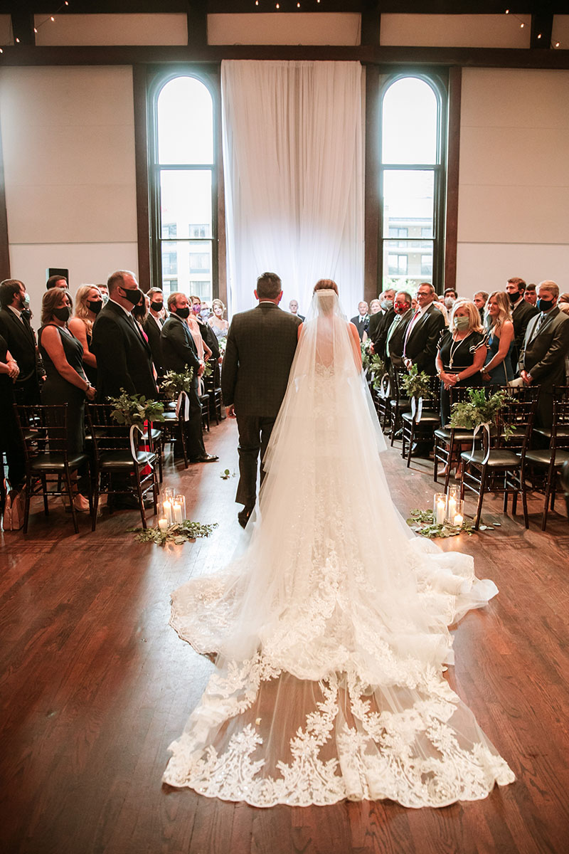 Bride begins to walk down aisle with dad during wedding ceremony