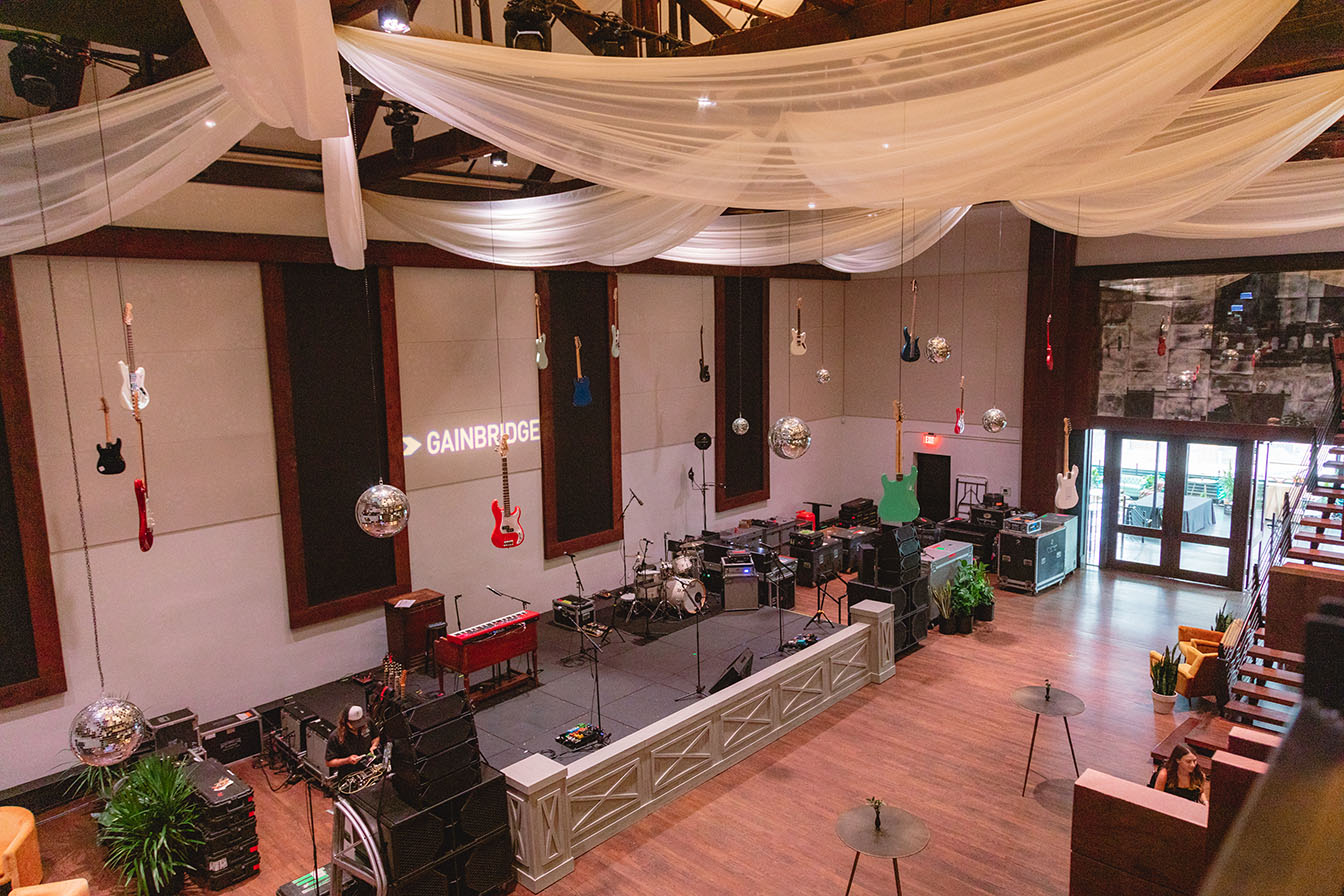 Bird's eye view of the main space with stage setup for live music, disco balls, and vintage guitars hanging from the ceilng