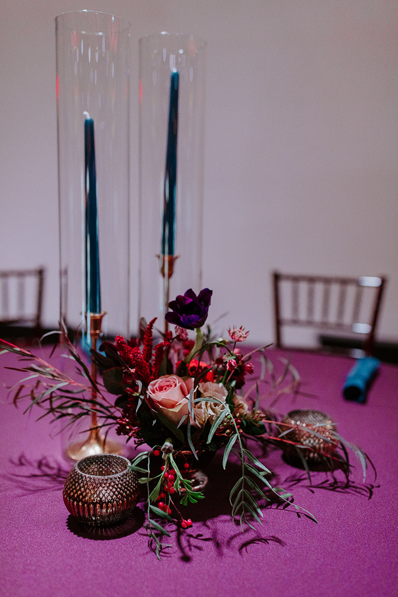 long stem candles with moody floral centerpiece