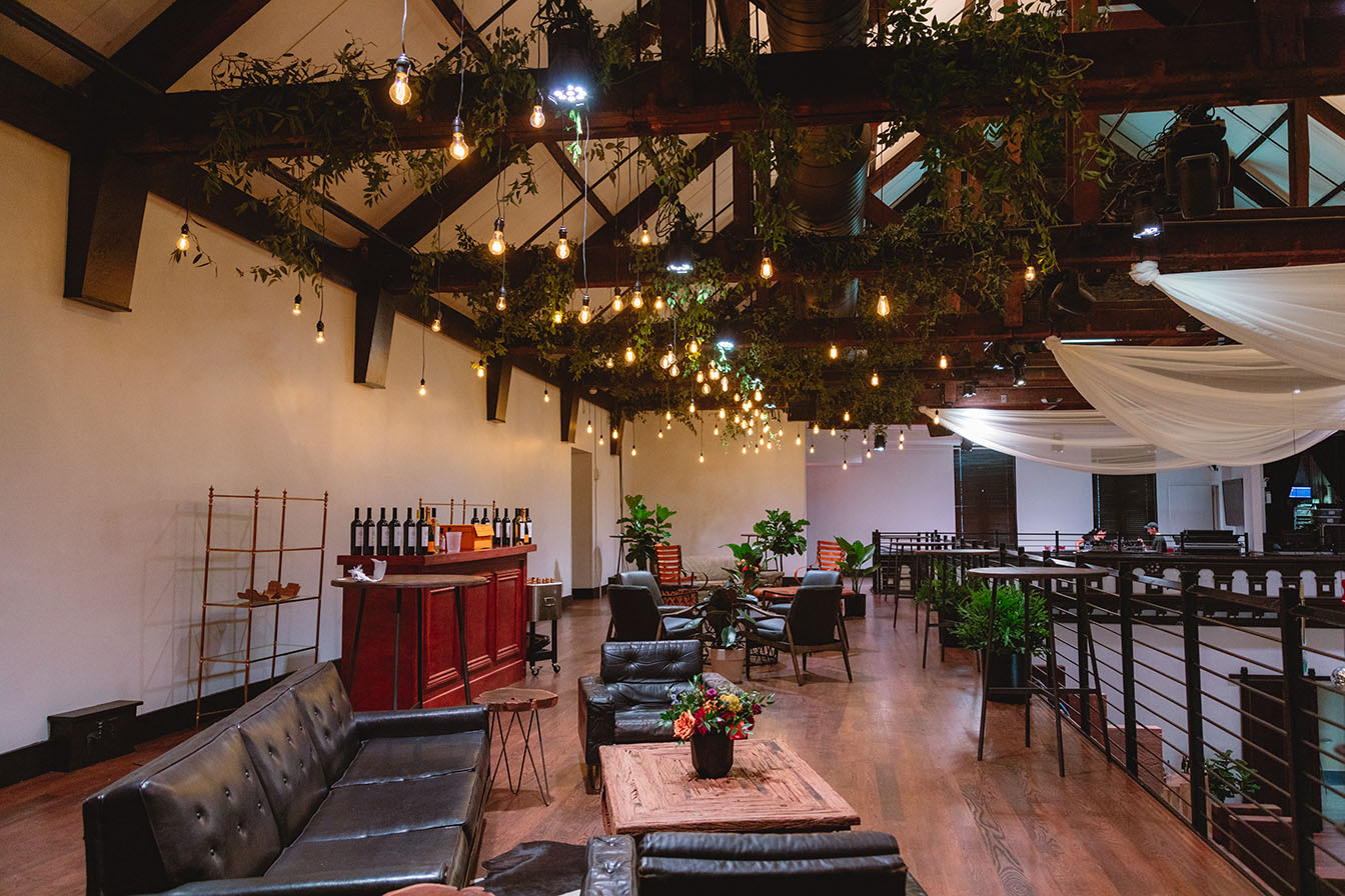 bar and lounge areas on mezzanine with hanging greenery and edison bulb lighting