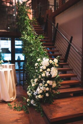 The Bell Tower staircase decorated with greenery and white flowers